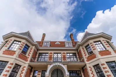a large brick building with a balcony at Hotel Villa Monte in Heist-op-den-Berg