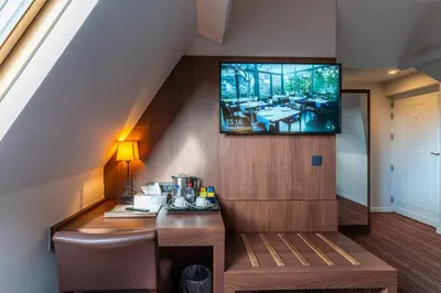a room with a table and a tv on a wall at Hotel Villa Monte in Heist-op-den-Berg