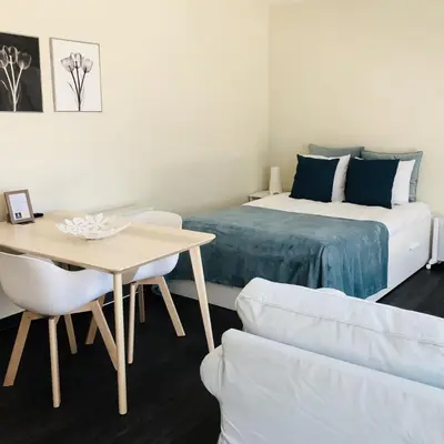 a bedroom with a bed and a table and a table and chair at Apartments Business Flats Brussels Airport in Zaventem