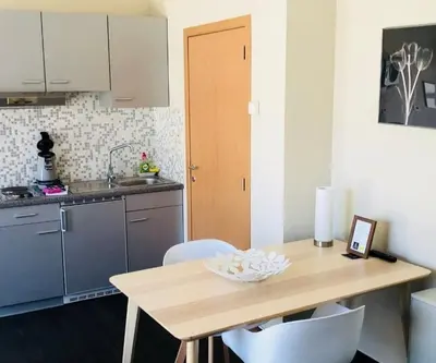 a kitchen with a wooden table with white chairs at Apartments Business Flats Brussels Airport in Zaventem