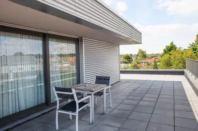 a patio with a table and chairs on a balcony at Hotel Rastelli Tervuren in Tervuren