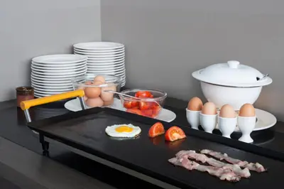a table with eggs eggs meat and tomatoes on a tray at Hotel Rastelli Tervuren in Tervuren