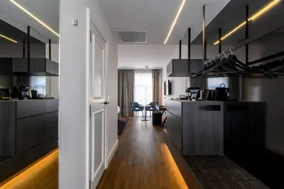 a kitchen with black cabinets and a dining room at Hotel Rubens-Grote Markt in Antwerp