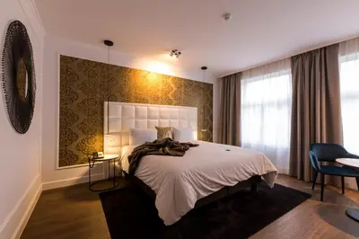 a bedroom with a large bed and a window at Hotel Rubens-Grote Markt in Antwerp