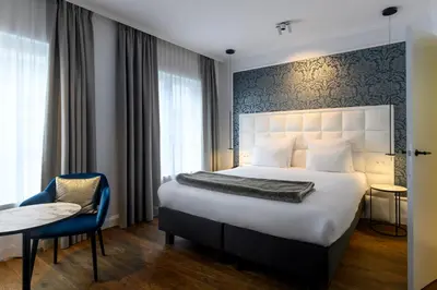a hotel room with a bed and a table and a chair at Hotel Rubens-Grote Markt in Antwerp