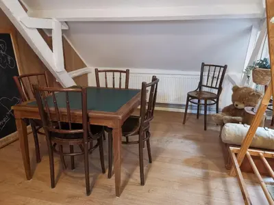 a dining room with a table and chairs and a teddy bear at Eremyten Hof in Evergem