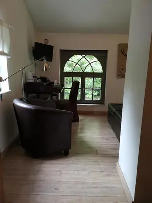 a living room with a couch and a table at Eremyten Hof in Evergem