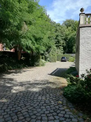 a cobblestone driveway with a car parked on it at Eremyten Hof in Evergem