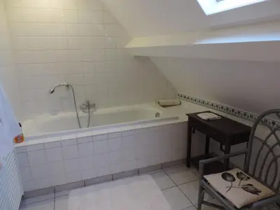 a bathroom with a bath tub and a table at Eremyten Hof in Evergem