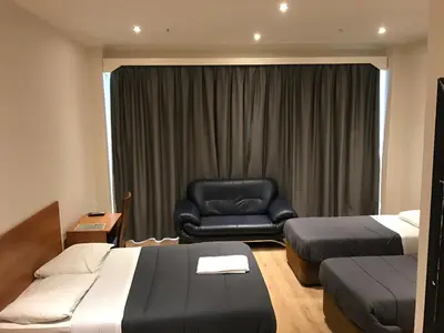 a hotel room with two beds and a leather chair at Royal Hotel in Brussels