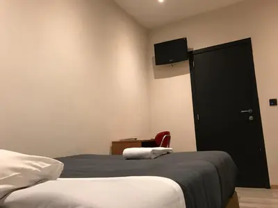 a bedroom with a bed and a tv on the wall at Royal Hotel in Brussels