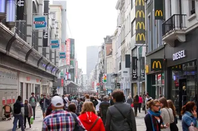 a crowd of people walking down a busy city street at Royal Hotel in Brussels