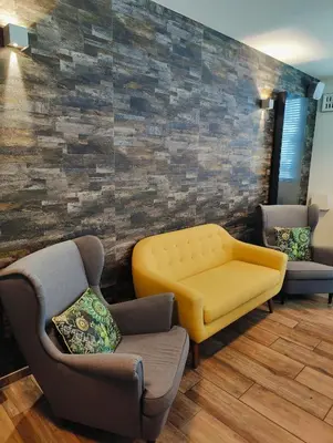 a waiting room with a yellow bench and chairs at Hotel Ladeuze in Leuven