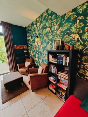 a living room with a couch and a book shelf at Hotel Ladeuze in Leuven