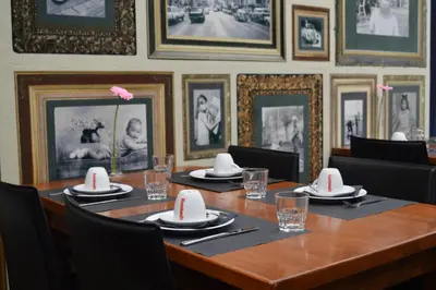a long wooden table with chairs and plates and napkins at Hotel Royal Zelzate in Zelzate