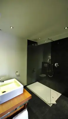 a bathroom with a shower and a sink and a tub at De Heidebloem in Zoersel