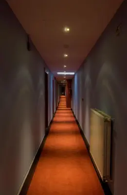 a long hallway with an orange floor in a building at De Heidebloem in Zoersel