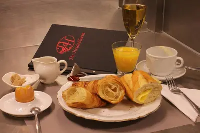 a plate of pastries on a table with a glass of wine at De Heidebloem in Zoersel