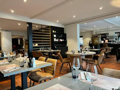 a restaurant with tables and chairs and a bar at De Heidebloem in Zoersel