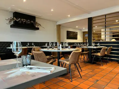 a restaurant with tables and chairs and wine glasses at De Heidebloem in Zoersel