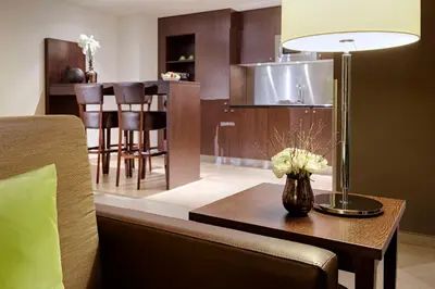 a living room with a table with a vase of flowers on it at Lindner Hotel Antwerp, part of JdV by Hyatt in Antwerp