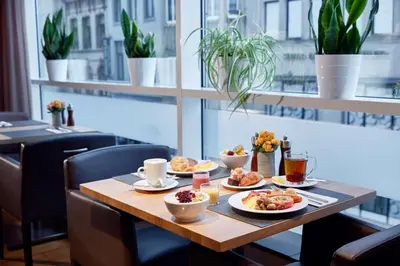 a wooden table with plates of food on it at Lindner Hotel Antwerp, part of JdV by Hyatt in Antwerp