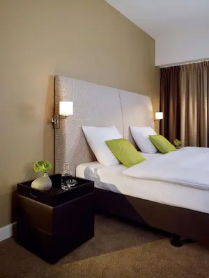 a hotel room with two beds with green pillows at Lindner Hotel Antwerp, part of JdV by Hyatt in Antwerp