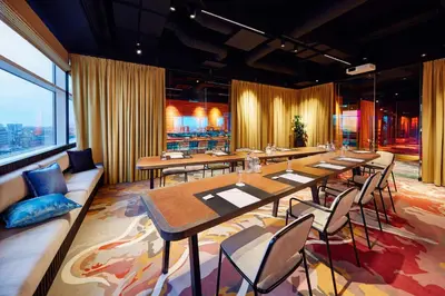a restaurant with tables and chairs and a large window at Lindner Hotel Antwerp, part of JdV by Hyatt in Antwerp