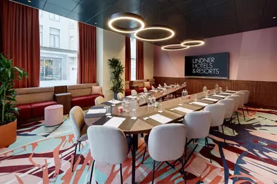 a conference room with a long table and white chairs at Lindner Hotel Antwerp, part of JdV by Hyatt in Antwerp