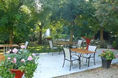 a group of tables and chairs in a garden with flowers at Aparthotel Malpertuus in Aalst