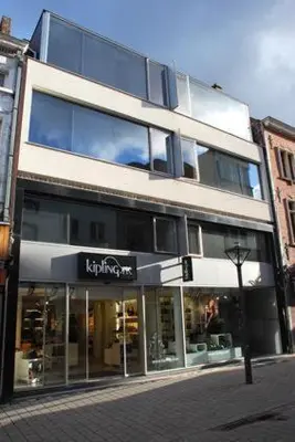 a large building on a city street with a store at Aparthotel Malpertuus in Aalst