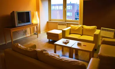 a living room with a couch and a tv at Ambassador Suites Antwerp in Antwerp