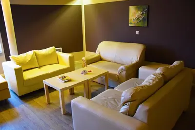 a living room with a couch and chairs and a table at Ambassador Suites Antwerp in Antwerp