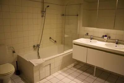 a bathroom with a tub and a toilet and a sink at Ambassador Suites Antwerp in Antwerp