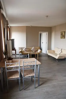 a living room with a couch and a table and chairs at Ambassador Suites Antwerp in Antwerp