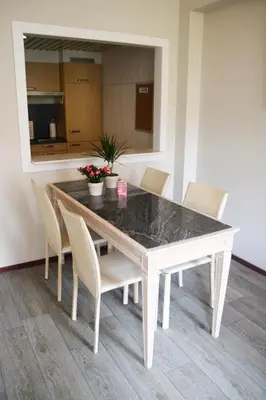 a dining room table with chairs and a black counter top at Ambassador Suites Antwerp in Antwerp