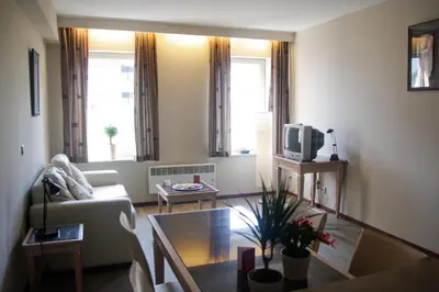 a living room with a couch and a table at Ambassador Suites Antwerp in Antwerp