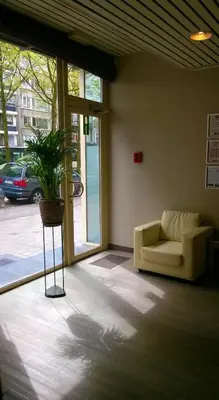 a living room with a couch and a potted plant at Ambassador Suites Antwerp in Antwerp