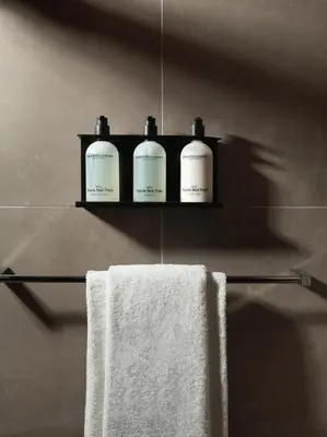 a bathroom with three bottles of soap on a shelf at The Dominican, Brussels, a Member of Design Hotels in Brussels