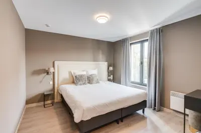 a bedroom with a bed and a large window at Hotel Italia in Zelzate