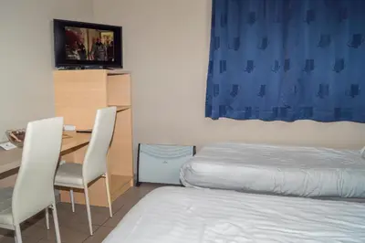 a bedroom with a bed and a desk and chairs at Budget Flats Leuven in Leuven