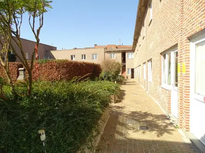 an alley with a brick building and a tree at Budget Flats Leuven in Leuven