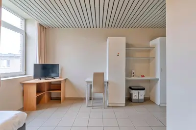 a room with a desk and a computer and a bed at Budget Flats Leuven in Leuven