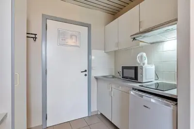 a kitchen with a white door and a microwave at Budget Flats Leuven in Leuven