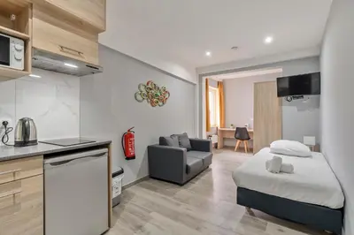 a kitchen and living room with a bed and a couch at Budget Flats Leuven in Leuven