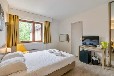 a hotel room with a bed and a television at Sleep & Go Brussels South in Waterloo