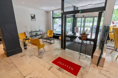 a lobby with yellow chairs and a red welcome mat at Sleep & Go Brussels South in Waterloo