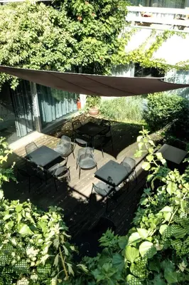 a patio with a table and chairs under an umbrella at Corbie Mol in Mol