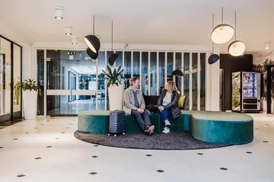 a man and woman sitting on a couch in a lobby at Corbie Mol in Mol