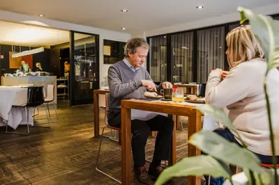 a man sitting at a table with a woman at Corbie Mol in Mol